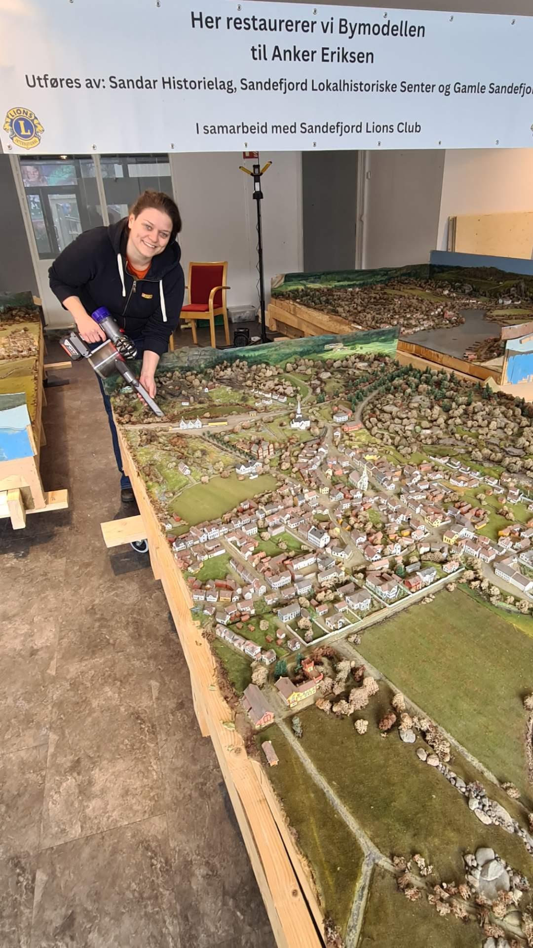 Kvinne som restaurerer modell av gamle Sandefjord by - Klikk for stort bilde